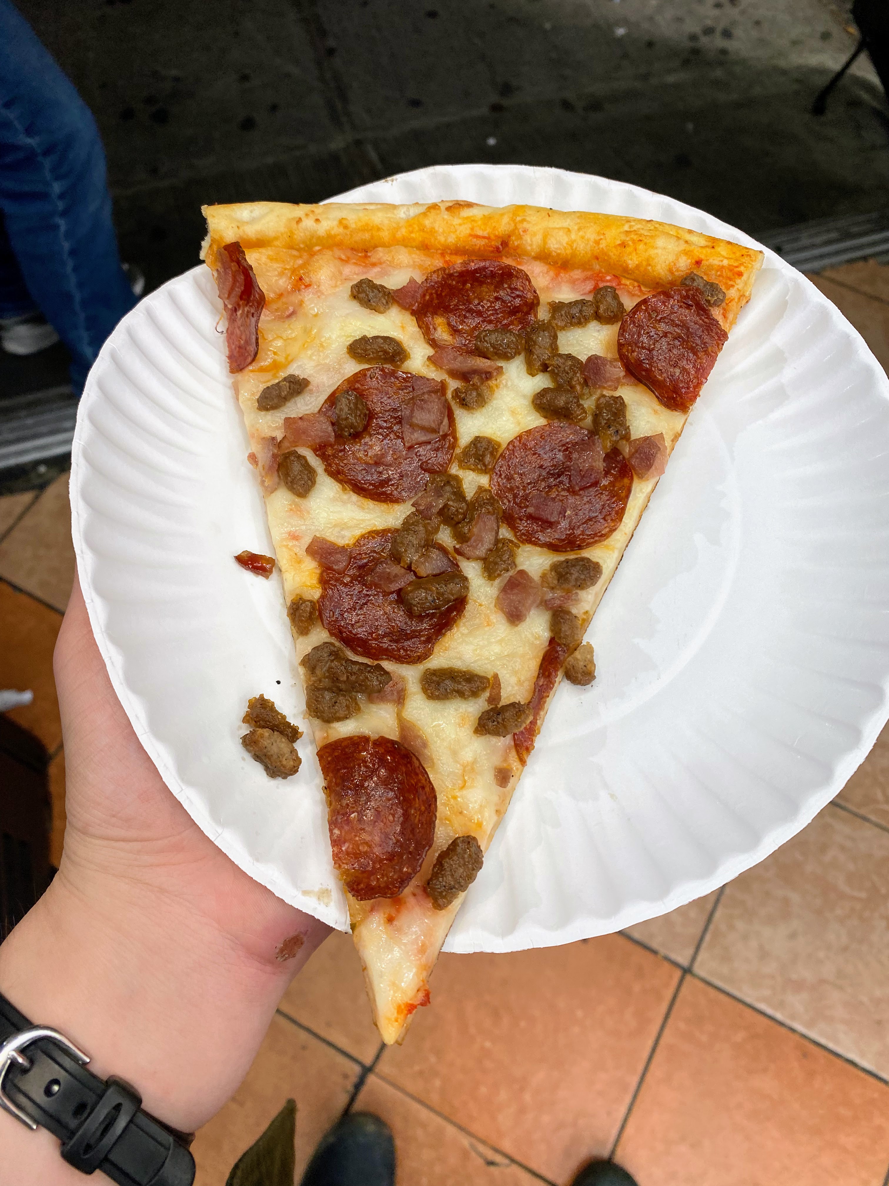 A slice of pepperoni and sausage pizza.